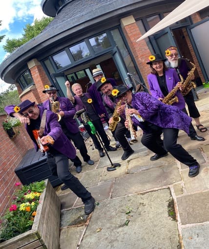 A group of people stood playing a rage of instrument
