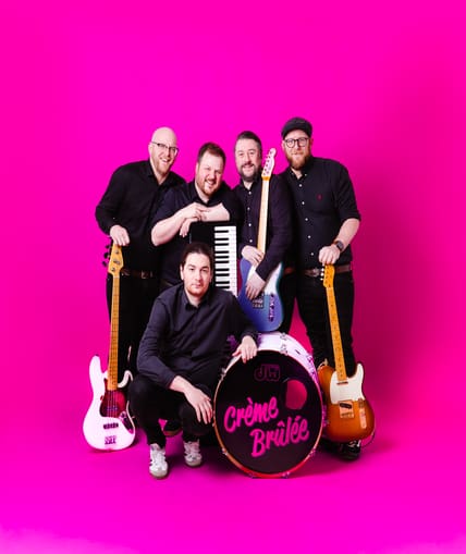 A band taking a promotional picture with a range of instruments