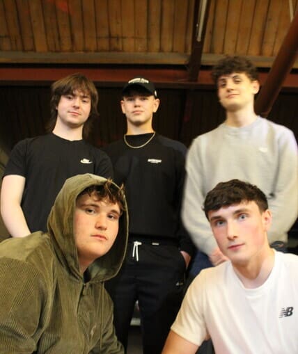A group of five people taking a group photo