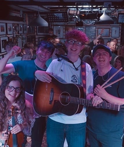 A group of four people performing to a large crowd