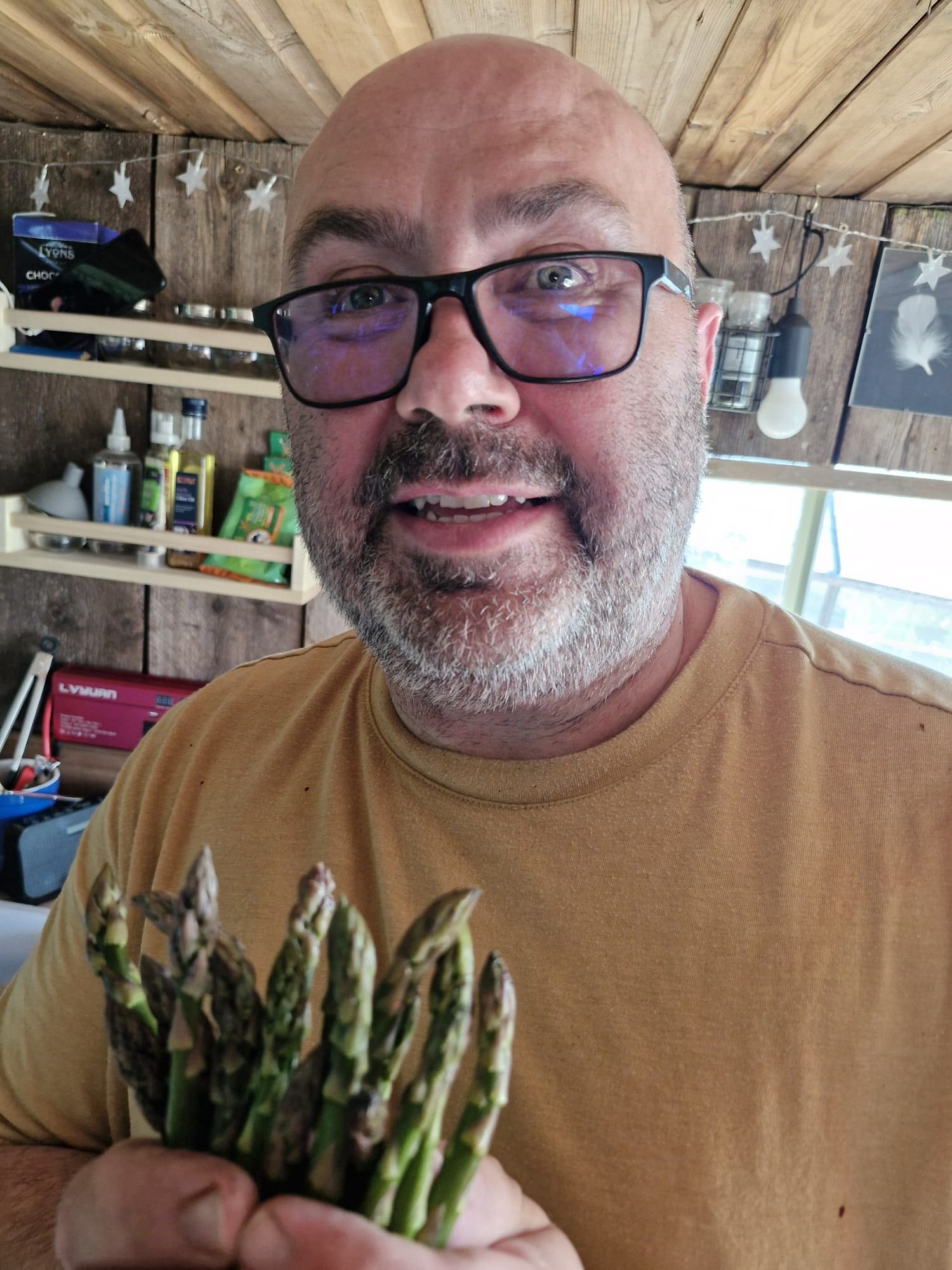 A chef stood holding some fresh asparagus