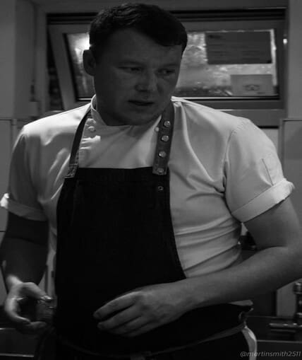 Black and white image of chef in an apron