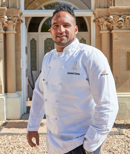 Chef stood outside in their chef whites taking promotional pictures
