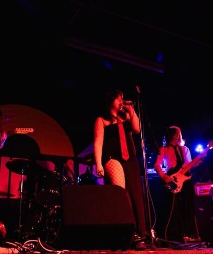 A band performing on stage to a large crowd