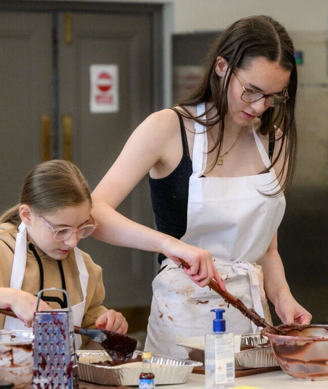 Two young people taking part in a chocolate making class