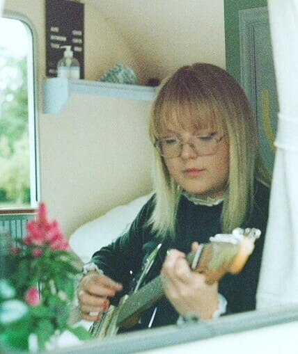 Musician sat down behind a window holding an instrument
