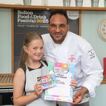 Michael Caines, TV Chef posing with young kitchen helper during cooking demo