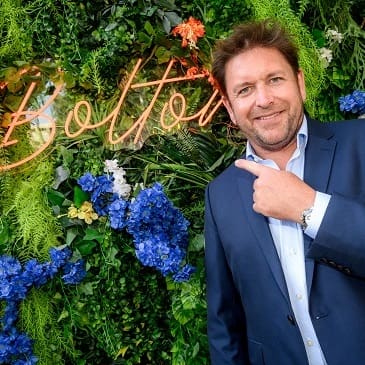 James Martin pointing to a sign that says 'Bolton'