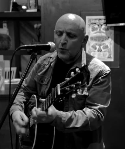 Musical performer on stage with guitar