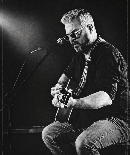 Musical performer on stage with guitar